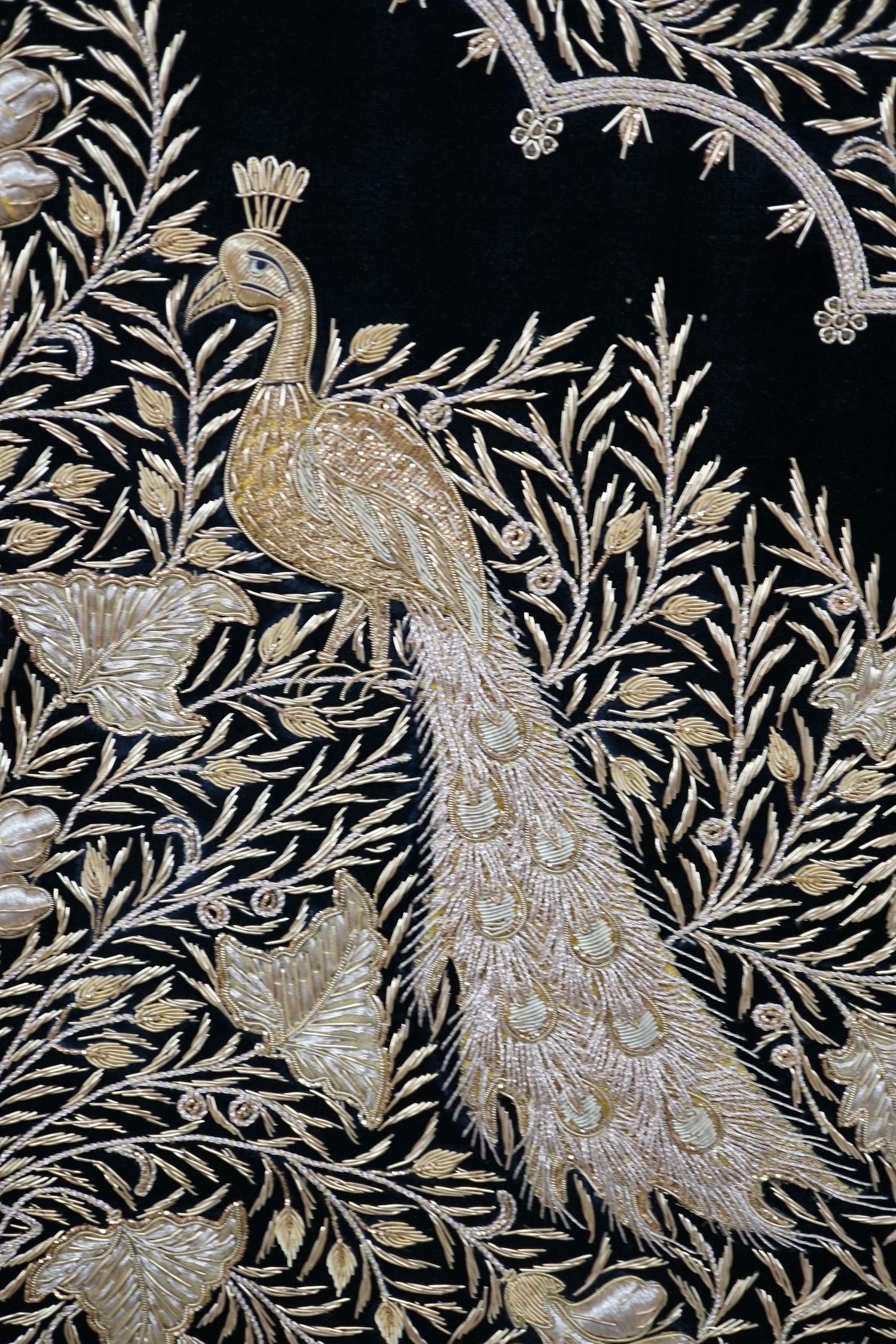 An Indian velvet and gold bullion work panel depicting two peacocks, 85 x 122cm. Condition - good